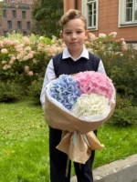 Свежий букет гипсофилы в крафт-обертке, подаренный мальчиком на улице в парке по теме "Вместо Слов".