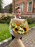 Мальчик с букетом цветов на улице возле жилого дома, осень, праздничное настроение.