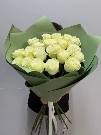 Розы в зелёной упаковке, букет свежих белых цветов, подарок или символ любви.