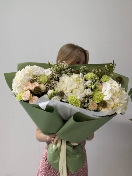 большой букет цветов с белыми и розовыми цветами в зеленой упаковке.