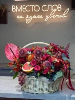 Роскошный цветочной букет в корзине с фруктами и яркими цветами, современное оформление.