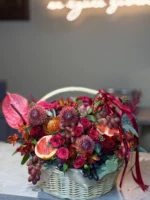 Свежий букет цветов с фруктами в корзине для подарка, яркое оформление.