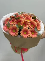 Альт текст: букет из розовых и оранжевых цветов с зеленью, оформление в упаковке.