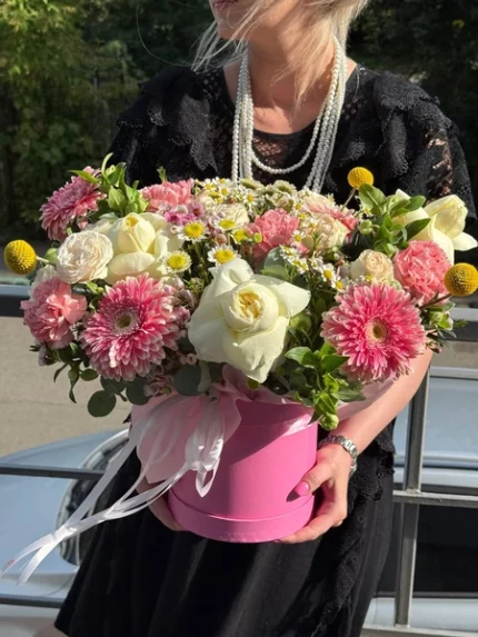 Красивая цветочная композиция в розовой коробке с розами и гвоздиками.