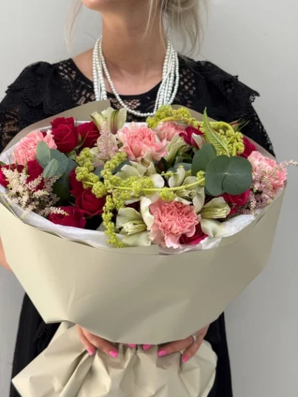 Букет цветов из роз, гвоздик и зелени в красивой обертке, праздничный подарок.