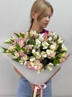 Букет из лепестков белых и розовых цветов с зеленью, девушка держит букет, цветы для особого случая.